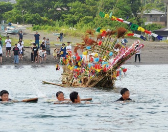 泳ぎながらオショロ船を引っ張る「セイトッコ」の中学生ら（＝18日、三戸海岸）