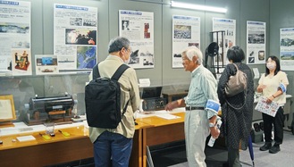 無線歴史展示室でスタッフから説明を受ける来場者