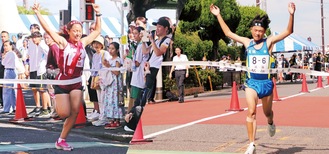 ゴールテープを切る追浜中６区・薄瑠一さん（右）と横須賀学院５区・小野愛凛さん