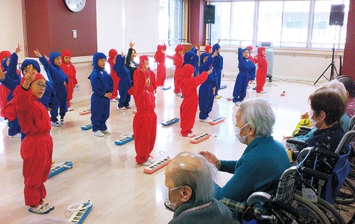 合唱する園児と見守る入居者