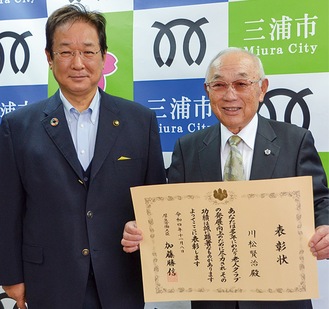 表彰状を手にする川松会長（右）と吉田市長