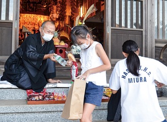 円徳寺で村山住職からお菓子などを受け取る子ども(昨年)