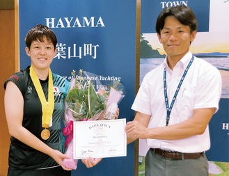 お祝いの花束を受け取り笑顔を見せる中田さん（左）