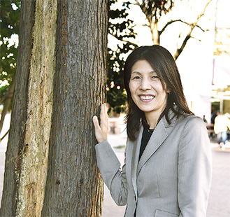 樹木医学会賞を受賞した太田教授横に立つ樹木は校内のスギで、幹の薄茶色の部分が病原菌による病気にかかっている部分