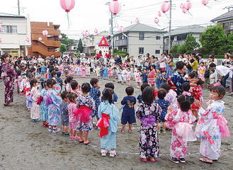 園庭で盆踊りをする園児