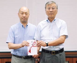 目録を手渡す山田理事長（左）