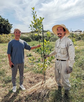 葛原の畑に植えられた苗木と中越代表（左）と原農園長