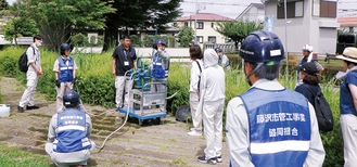 ポンプを使った取水法を指導する組合員