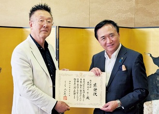 黒岩知事から感謝状を受け取る吉楽代表（左）