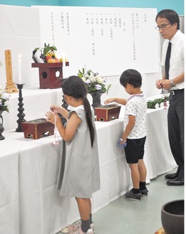 焼香台で手を合わせる園児たち