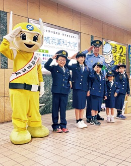 一日署長として敬礼する児童ら