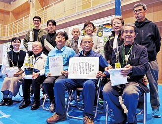 ハマボウの苗木や賞状を手にする湘南海浜植物育成会会員ら＝９日、辻堂公民館まつり会場で