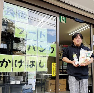 寄付された食材を手にする高見代表