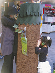 「ぴぴ☆しあたー」を観賞する子ども。木の筒を覗くと人形劇が行われている