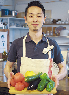 熊本から届いたばかりの食材を持つ山内さん