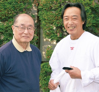 ｢年末はおいしいおそばを食べて飛躍の年にしてください｣と戸井田組合長(左)と今泉さん