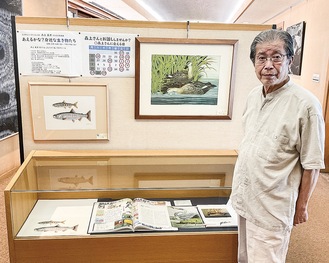 森上さんと原画などの展示資料＝茅ヶ崎市立図書館