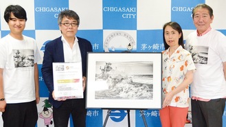 日本代表作品｢激闘｣を寄贈した写真家の小林鉄斎さん(左から２番目)＝６月25日、茅ヶ崎市役所本庁舎