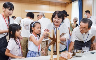 繭から糸を巻き取る作業を体験