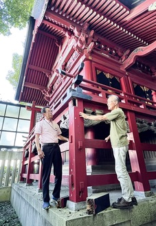 倉見神社の本殿を確認する磯川委員長（左）と委員会メンバーの磯川彰さん。足元には腐朽した木材が置かれている