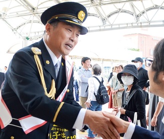 啓発物を配布し握手する山本昌さん