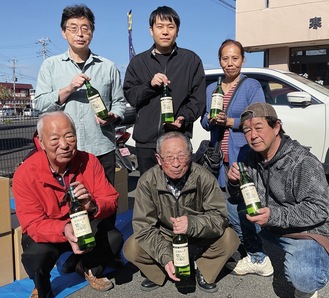 梨ワインを持つ酒販組合寒川支部のメンバー