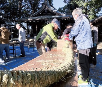 藁をねじりながら編んでいく神社関係者＝倉見神社境内