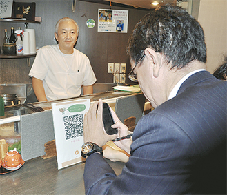 ＱＲコードからスマホで決済する河野委員長