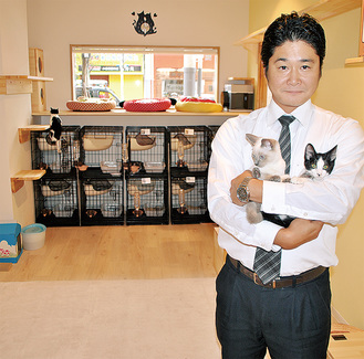 開店を控える店内。猫を抱く井上さん