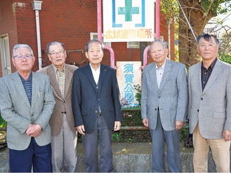 「須賀公園」の看板前に立つ須賀史談会のメンバーら