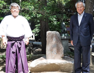 奉遷塚を囲む宅野宮司（左）と福澤さん