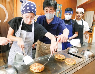 緊張しながらお好み焼きを焼く参加者