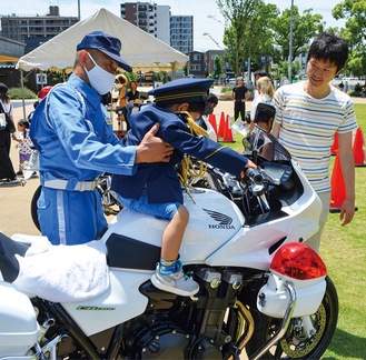 制服に身を包み、白バイにまたがる来場者