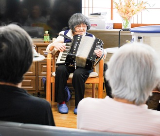 利用者の前でアコーディオンを弾く大庭さん