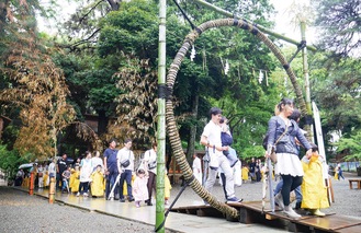 茅の輪をくぐる園児と保護者