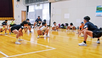 体育館で運動する児童ら