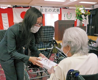 祝いの品を渡す大畑美歩施設長