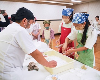 和菓子作りをする中学生と小林さん（左）