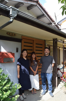 祷龍館の跡地に立つ拠点の前で（左から）西村さん、萩原さん、大塚さん