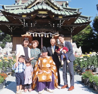 拝殿の前で記念撮影をする様子（田村八坂神社提供）