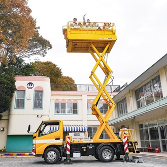 高所作業車に乗る園児ら