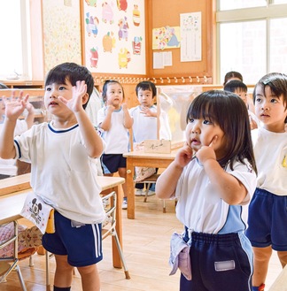 振付を元気よく踊りながら歌う園児