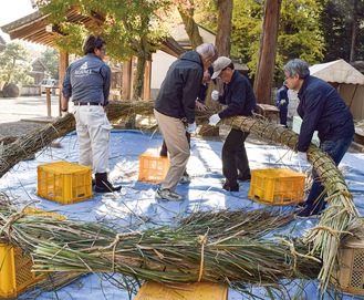 声を掛け合いながら茅を巻き付ける様子（川勾神社）