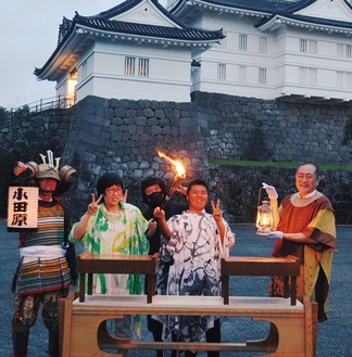 小田原城天守閣の前で、ランタンに移された火（右端）