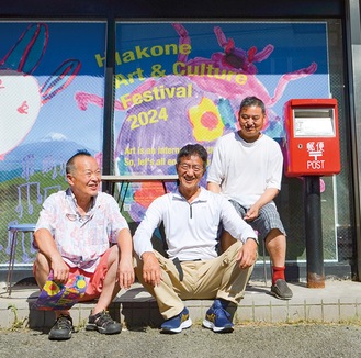 コラージュ作品の前で、芸術祭への来場を呼び掛ける遠藤桂さん（左）ら