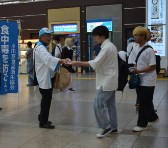 食中毒予防の啓発グッズを渡す＝小田原駅前