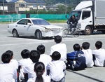 自転車事故の再現を見つめる生徒