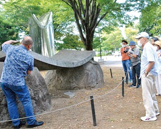 彫刻鑑賞の説明を受ける参加者（同協会提供）