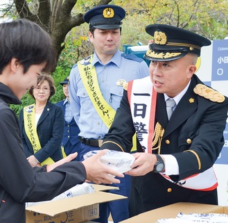 防犯グッズを手渡し、注意喚起を促す松尾さん