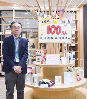 東口図書館の統括責任者の青柳さんと１００万人達成記念の選書コーナー